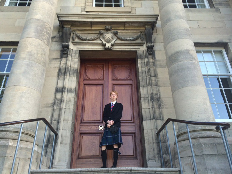 Foto-Fabian-Lucht-web Schüler steht vor einer großen Tür aus Holz.